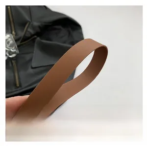 Close-up detail of the brown leather shoulder strap with premium textured finish