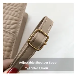 Detail of beige leather strap with adjustable antique gold buckle and pebble texture
