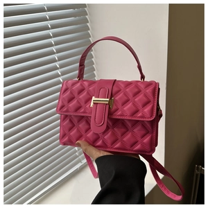 Macro shot of 3D quilted rose pink shoulder bag with gold metal buckle and hand strap
