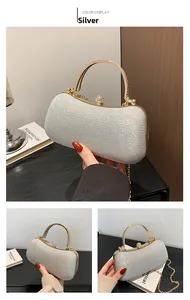 Détail macro d'une pochette argentée pailletée avec poignée dorée et fermoir diamanté