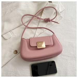 Pink leather shoulder bag with gold buckle shown next to phone for size reference
