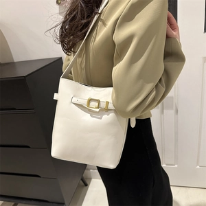 Minimalist white leather bucket bag with gold buckle detail and slim shoulder strap