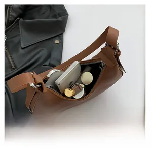 Brown crescent shoulder bag interior showing capacity for phone and cosmetics