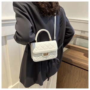 Détail du sac à bandoulière matelassé blanc avec fermoir doré et poignée élégante