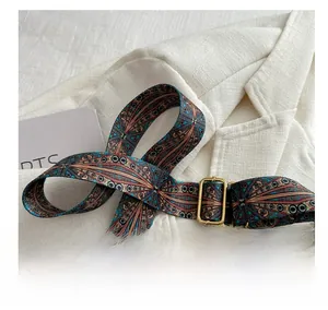 Close-up of vintage geometric pattern wide shoulder strap with bronze metal buckle