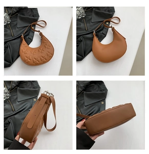 Detail view of brown hobo bag showing embossed clover pattern and adjustable silver buckle
