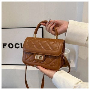 Détail du sac bandoulière matelassé marron caramel avec fermoir doré et poignée supérieure
