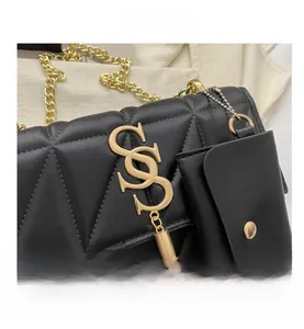 Détail d'un sac bandoulière noir matelassé avec chaîne dorée et breloque logo S chic