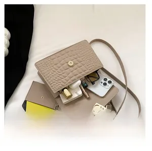 Internal view of beige crocodile embossed crossbody bag showing capacity for daily essentials