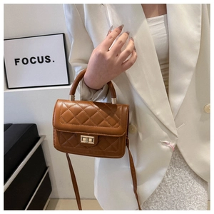 Détail du sac matelassé caramel avec fermoir rotatif doré et poignée supérieure élégante