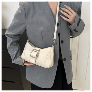 Détail du sac baguette en similicuir blanc crème avec boucle argentée et bandoulière