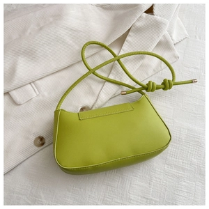 Detail of avocado green leather shoulder bag with knotted strap and gold hardware