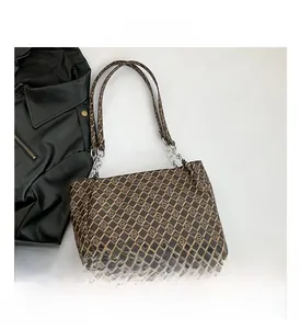 Detail of brown monogram tote bag with diamond pattern and metallic chain strap