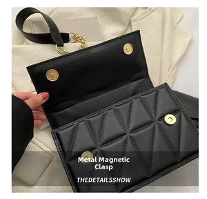 Détail du sac à main matelassé noir avec motif géométrique et fermoir aimanté doré