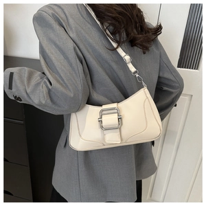 Sac baguette en cuir blanc cassé porté par un mannequin pour un look urbain chic