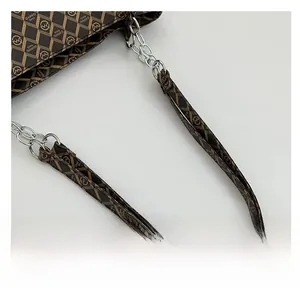 Detail of checkered brown leather and silver chain strap on a large tote bag