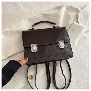 Détail du sac à dos vintage marron foncé montrant les boucles et la texture du cuir mat