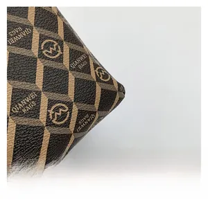 Close-up of geometric diamond pattern on brown tote bag with premium leather texture