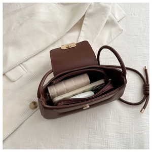 Interior detail of a brown PU crossbody bag showing storage space for phone and wallet