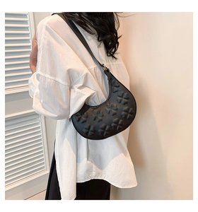 Détail du sac demi-lune noir avec gaufrage trèfle 3D et fine bandoulière élégante