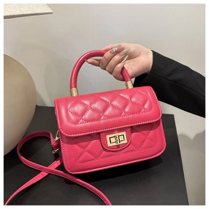 Vue détaillée du sac matelassé rouge rose avec fermoir rotatif doré et une poignée