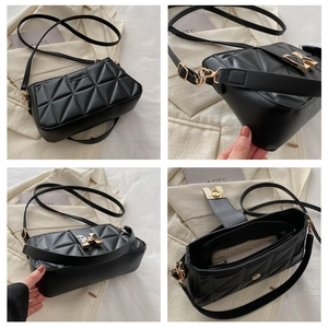 Detail view of black quilted faux leather crossbody bag with golden H clasp and compartments