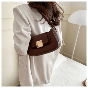 Detail of dark brown leather shoulder bag featuring a gold square buckle and knotted handle