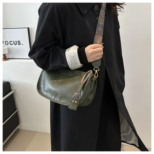 Close-up of vintage dark green Boston bag with ethnic embroidery wide shoulder strap