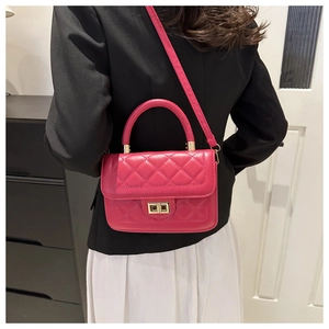 Détail d'un sac bandoulière matelassé magenta avec fermoir doré et poignée ronde