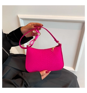 Detail of fuchsia crocodile pattern bag with pink resin chain and gold zipper