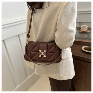 Detail view of brown quilted handbag with golden H-clasp and adjustable strap