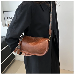 Detailed view of the brown vintage cylinder bag with textured leather and patterned strap