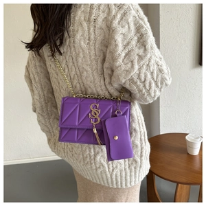 Detail of purple quilted shoulder bag with gold chain strap and mini pouch accessory
