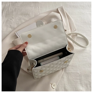 Interior view of white quilted crossbody bag with gold magnetic clasp and phone storage