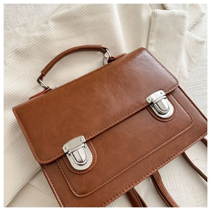 Détail d'un sac à dos vintage en cuir PU marron avec boucles et poignée de transport
