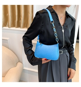 Detail of blue faux crocodile pattern shoulder bag with a unique link chain strap