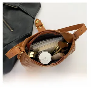 Internal capacity view of brown quilted underarm bag with phone and cosmetics
