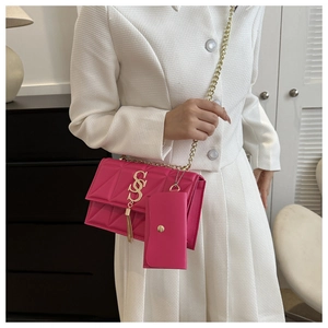 Détail du sac matelassé rose avec logo S doré, gland à franges et breloque porte-monnaie