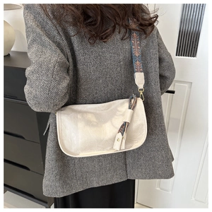 Detail of cream crossbody Boston bag with ethnic pattern strap and silk scarf knot detail