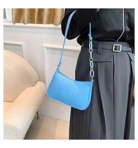 Detail of light blue faux crocodile leather shoulder bag with resin and metal chain strap