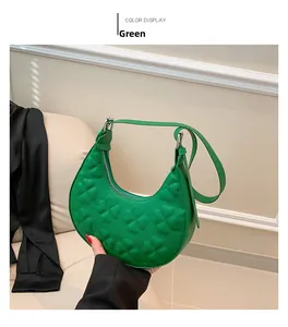 Detailed close-up of a green crescent bag featuring an embossed clover pattern and PU leather