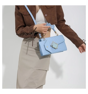Detail of light blue crocodile texture bag with gold buckle and matching mini pouch