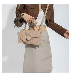 Detail of apricot crocodile texture handbag with dual diamond metal buckles and pleated handle