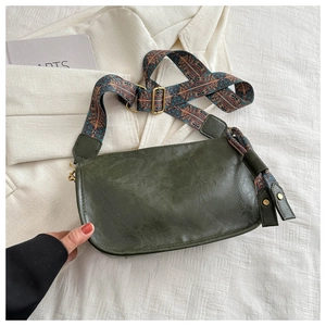 Detail of dark green vintage Boston bag with adjustable ethnic pattern wide shoulder strap