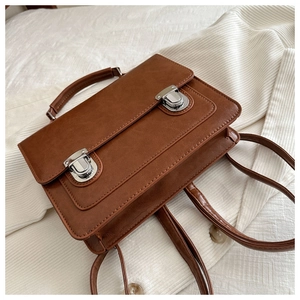 Détails du sac vintage marron avec boucles argentées et coutures de précision