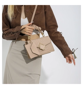 Detail of beige crocodile pattern handbag with metal buckle and small coin purse