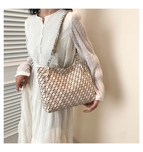 Macro shot of stylish large tote bag with brown monogram print and chain strap