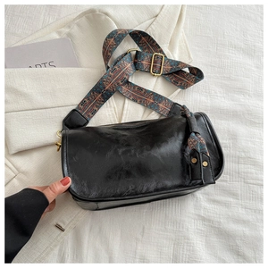 Fashionable black PU leather cylindrical crossbody bag with colorful woven shoulder strap