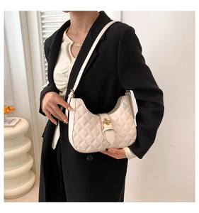 Close-up of cream quilted hobo bag featuring fine stitching and gold buckle detail