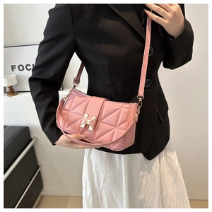 Detail of pink quilted crossbody bag with H-shaped metal buckle and chain strap